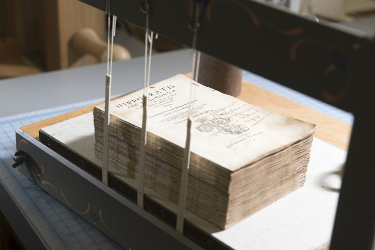 Photo of a book being repaired and readied for sewing