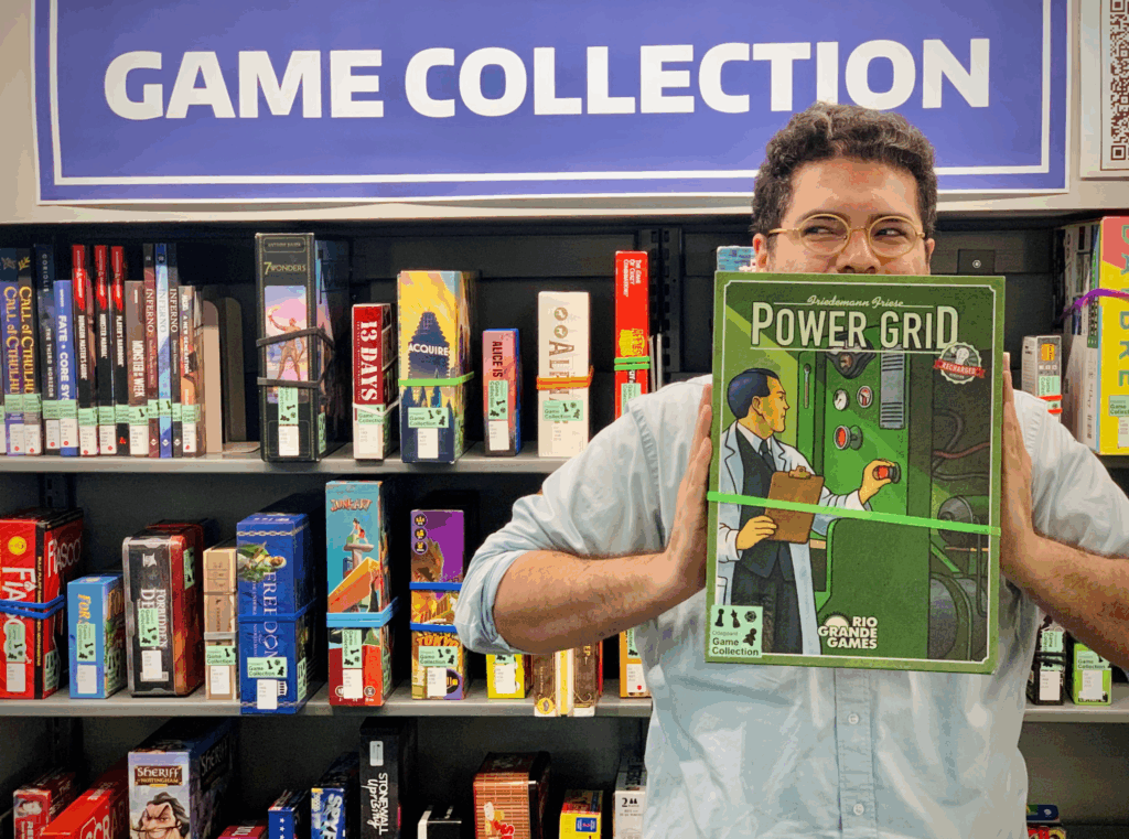Someone stands in the game collection section holding up a board game