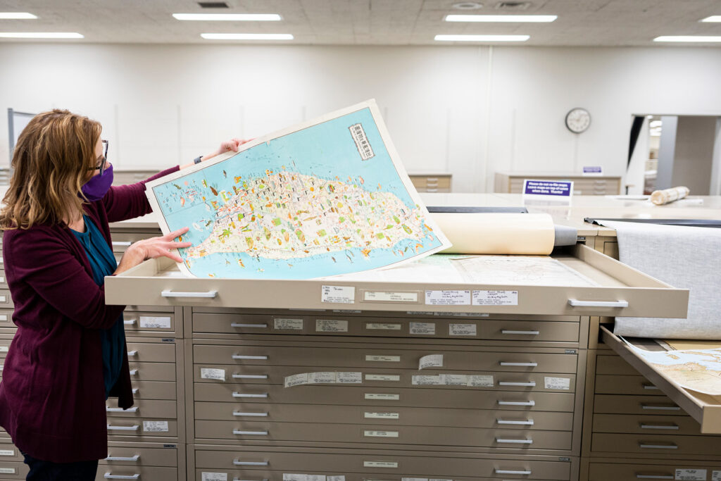 Photograph of a librarian examining a map