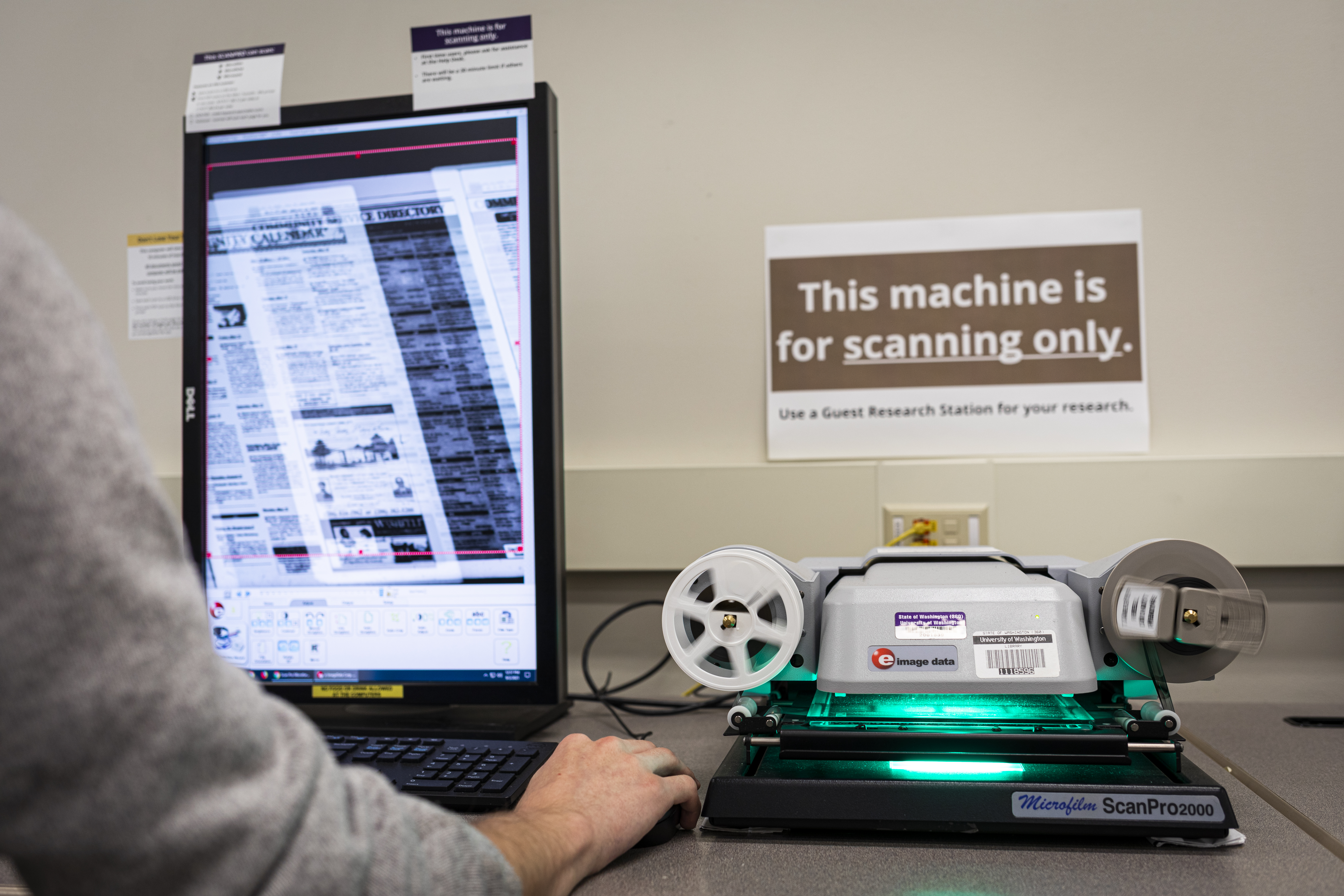 Photo of someone threading microfilm through a viewer