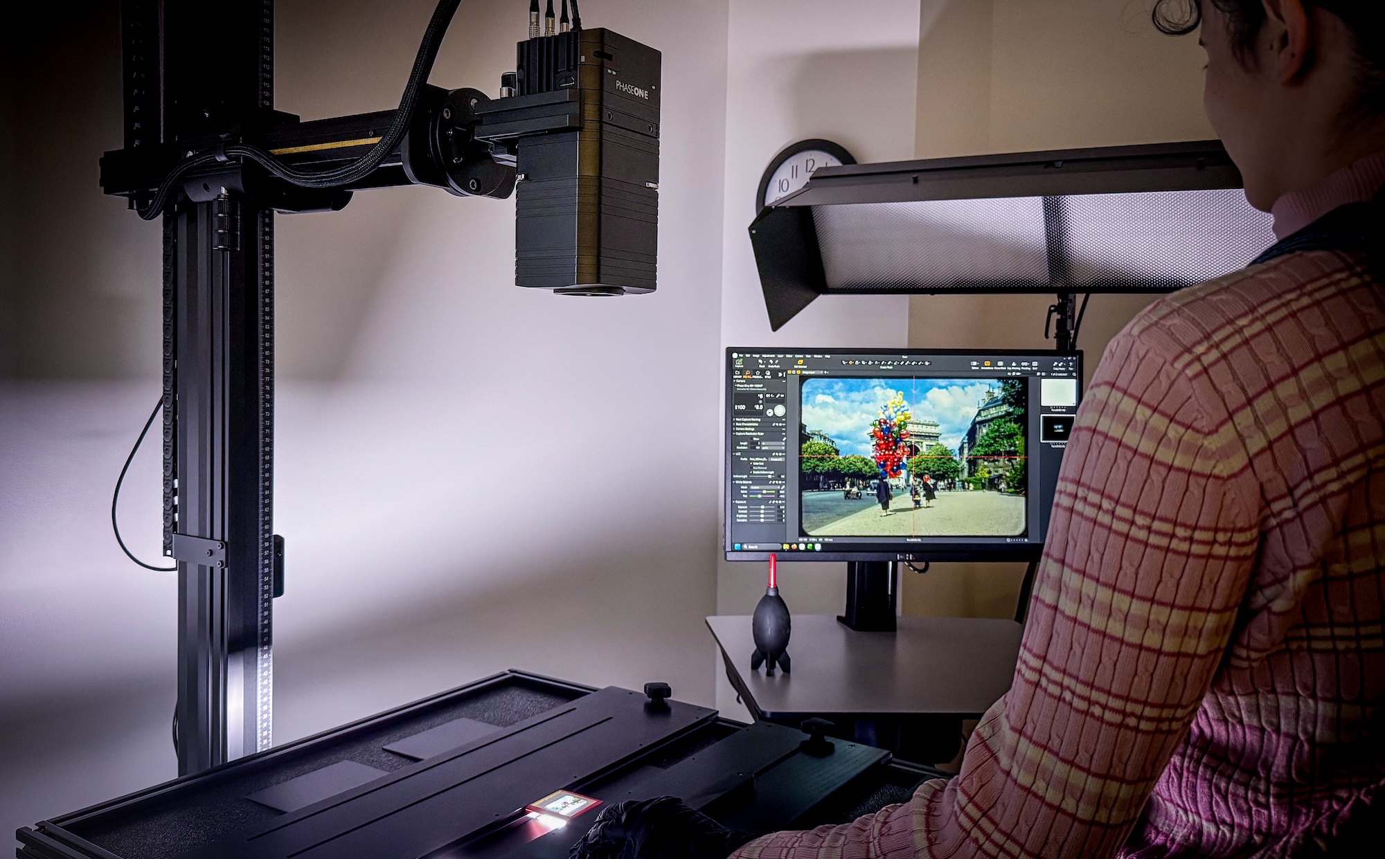 Photo of Preservation staff examining a digital image of a color slide of Paris