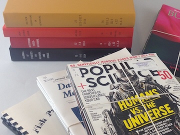 Photo of a stack of bound journals and some unbound journal issues tied together