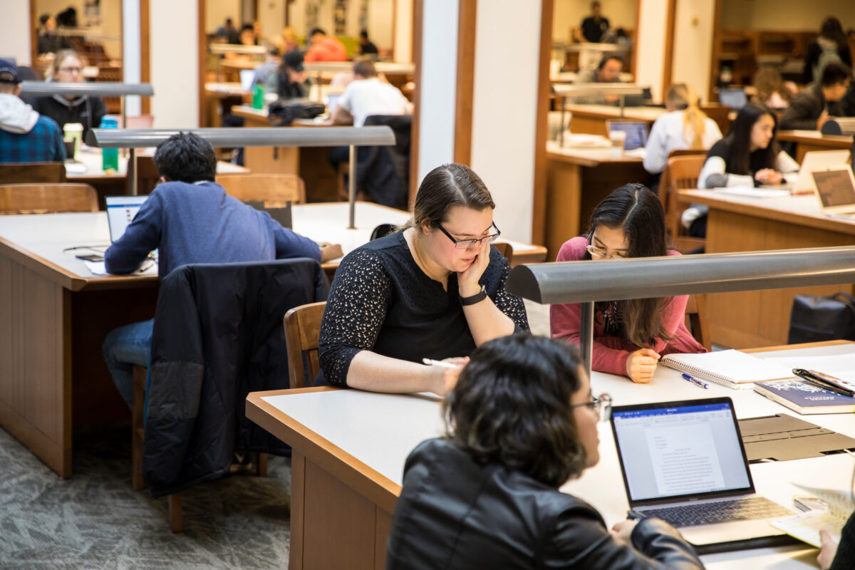 Students studying at desks in Foster Business Library.